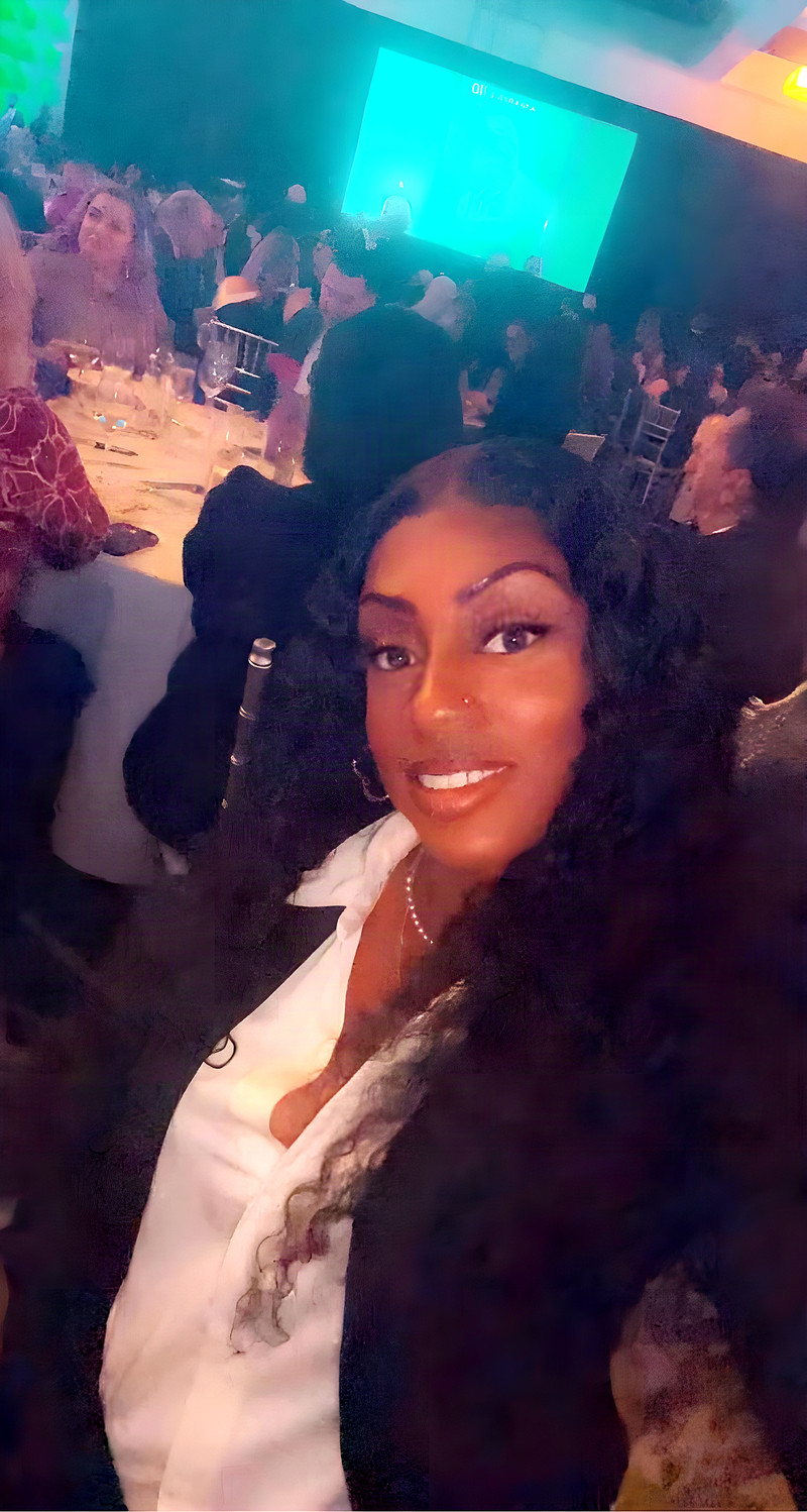 Janay Lewis at a formal gala dinner, white blouse and long curls