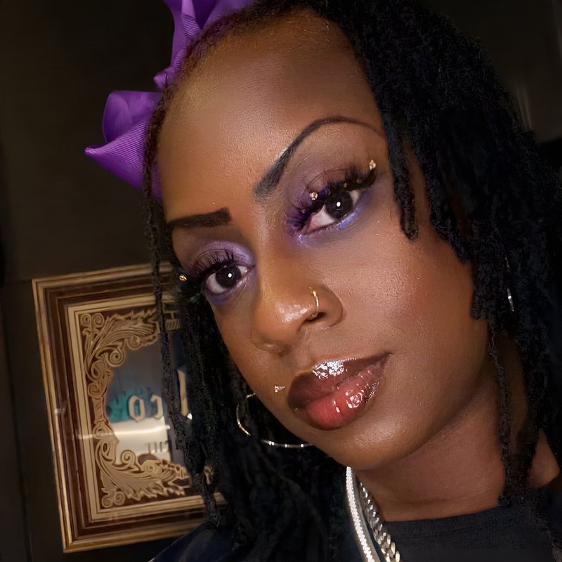 Janay Lewis wearing Locs with a purple bow
