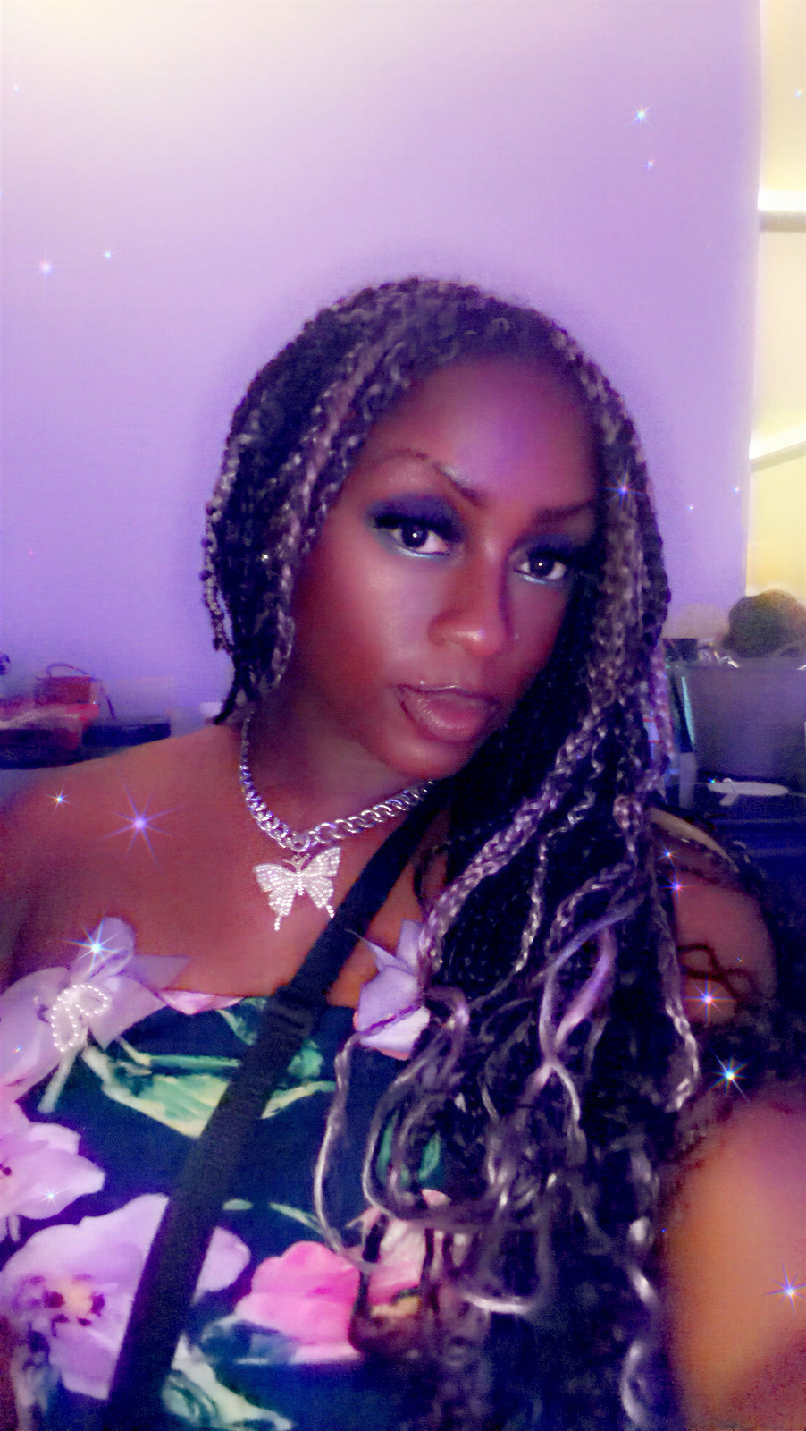 Janay Lewis in her own braids against a soft purple wall