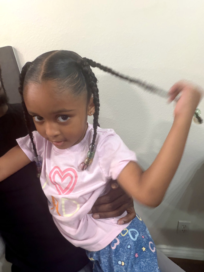 Little girl showing off her fresh braids with beads
